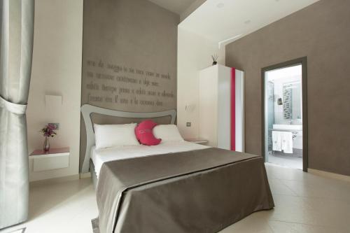 una camera da letto con un letto con un peluche rosso sopra di Hotel Nunù a Napoli