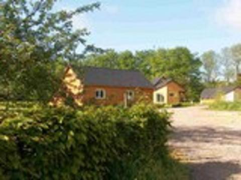 a red brick house in front of a house at La Ferme Pillet in Berville
