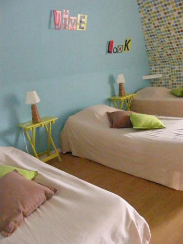 a room with two beds and a wine sign on the wall at La Ferme Pillet in Berville