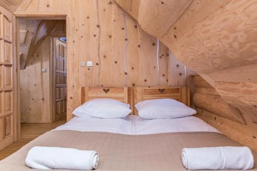 a bedroom with a bed in a log cabin at udanypobyt Domek Skocznia in Zakopane