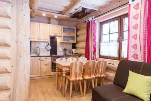 a kitchen and dining room with a table and chairs at udanypobyt Domek Skocznia in Zakopane