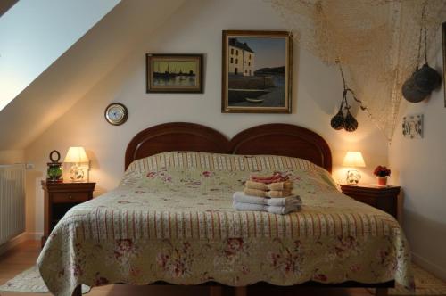 ein Schlafzimmer mit einem Bett mit zwei Lampen und Handtüchern in der Unterkunft Ti Er Mad in Kernascléden