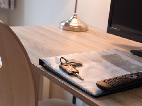 a padlock sitting on a table next to a remote control at Hotel Åberg Centralhotellet in Tranås