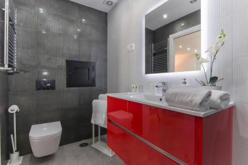 a bathroom with a red sink and a toilet at Plaza España & Gran Via 2BD 1BTH in Madrid