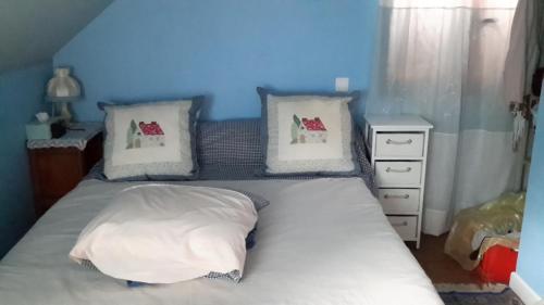 une chambre avec un lit avec des draps blancs et des oreillers dans l'établissement le casino, à Florentin-la-Capelle