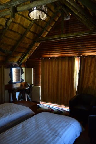 a bedroom with two beds and a desk in a room at Namibs Valley Lodge in Gamsberg Pass