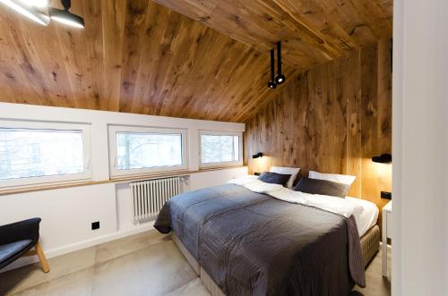 1 dormitorio con cama y techo de madera en Apartament Dębowy, en Stronie Śląskie