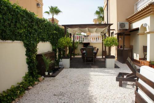 a courtyard with a table and chairs in a building at villa las tres perlas in Algorfa