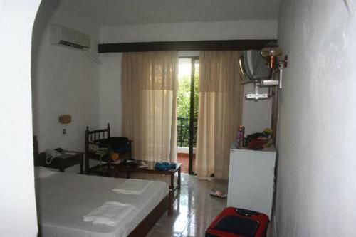 una camera con un letto e una finestra di Oasis Hotel Bungalows Rhodes- All Inclusive a Afantou