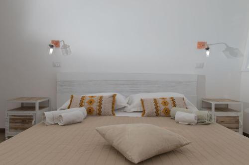 um quarto com uma cama grande com almofadas em Appartamento Mykonos em Lido di Ostia