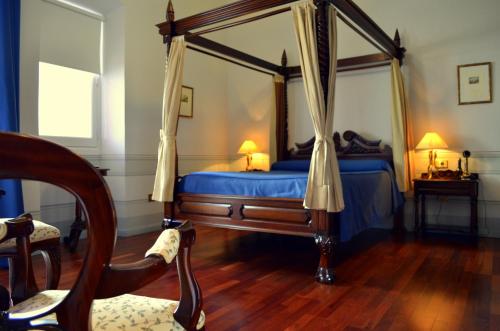 1 dormitorio con cama con dosel y sábanas azules en Hospedería Mirador de Llerena, en Llerena
