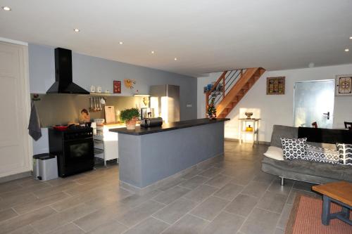 una amplia cocina y sala de estar con sofá y encimera en Le 46, en Saint-Sauver-la-Sagne