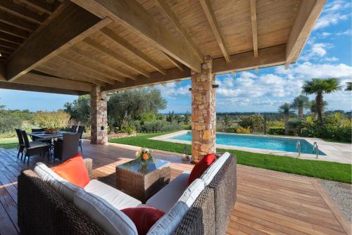 Blue & Green View Villa في Asgourou: فناء مع أريكة وطاولة ومسبح