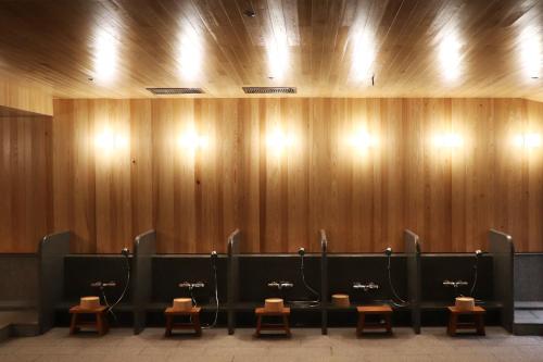 a row of urinals in a restroom with wooden walls at Asia Pacific Hotel Beitou in Taipei