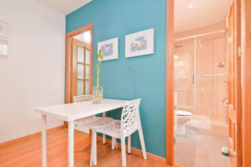 ein Esszimmer mit einem weißen Tisch und einer blauen Wand in der Unterkunft Ático en el Centro de Madrid - Calle Jardines in Madrid