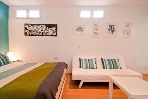 ein Schlafzimmer mit einem Bett, einem Sofa und einem Tisch in der Unterkunft Ático en el Centro de Madrid - Calle Jardines in Madrid