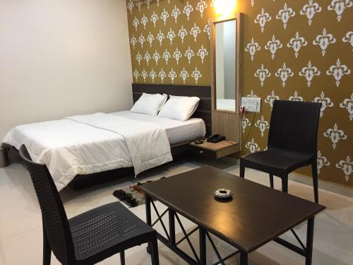 um quarto com uma cama, 2 cadeiras e uma mesa em Hotel Sheetal em Wadgaon