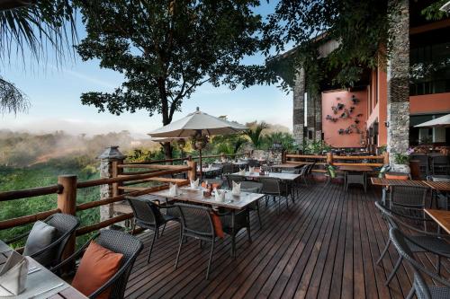 a restaurant with tables and chairs on a wooden deck at Katiliya Mountain Resort And Spa in Mae Salong Nai