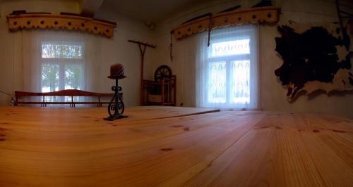 an empty room with a wooden floor and two windows at Kačiūniškis in Kaciūniškiai