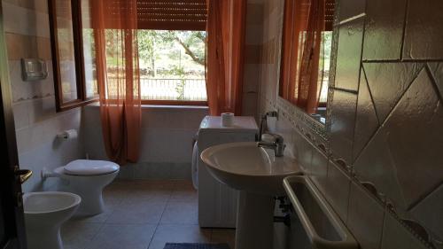 a bathroom with a sink and a toilet and a window at Villa San Gavino in Budoni