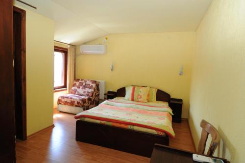 1 dormitorio pequeño con 1 cama y 1 silla en Family Hotel Studio en Sandanski