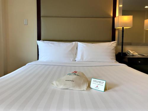 a hotel room with a bed with a sign on it at Jinjiang Inn - Boracay Station 1 in Boracay