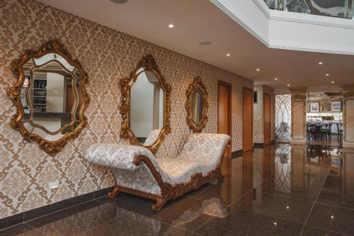 a room with a chair and mirrors on the wall at Golden Lis Hotel Boutique in Goiânia