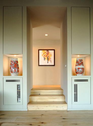 a hallway with a staircase and two vases on the wall at Villaflair - Design Villa Porto Ercole in Monte Argentario