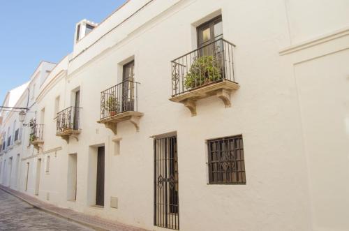 un edificio blanco con balcones en una calle en Apartamentos Tarifa Castillo, en Tarifa