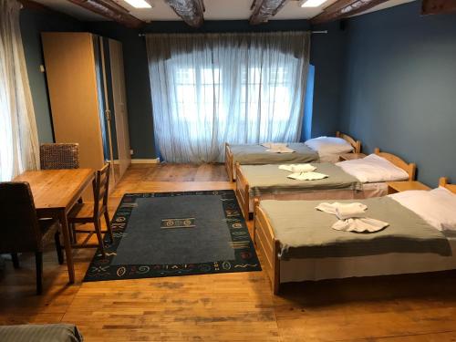 Zimmer mit 4 Betten, einem Tisch und einem Fenster in der Unterkunft Durty Nelly's Pub in Prag