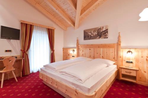 a bedroom with a large bed and a desk at Brunnerhof Klausen-Chiusa in Chiusa
