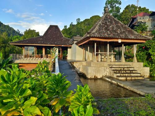 un edificio accanto a un corpo idrico di Melanting Cottages a Munduk