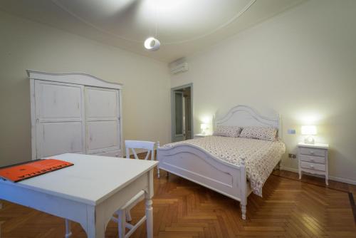 a bedroom with a white bed and a table at Adelaide Central Apartment in Milan