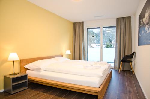 a hotel room with a bed and a window at Apartment Ankebälleli - GriwaRent AG in Interlaken