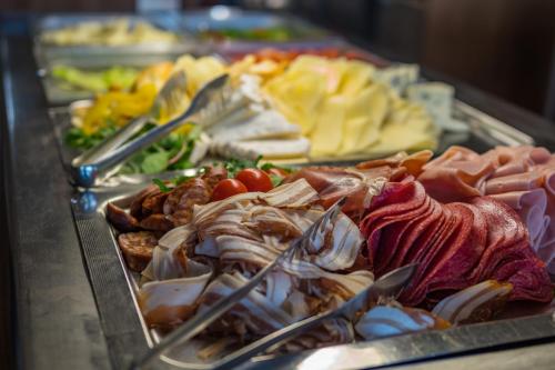 a buffet with many different types of food on display at Hotel International in Tatranská Lomnica