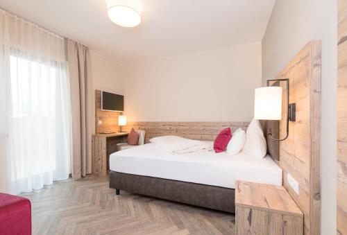 a hotel room with a bed and a desk at Alpenhotel Tirolerhof in Fulpmes