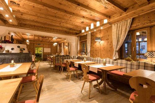 a restaurant with wooden ceilings and tables and chairs at Alpenhotel Tirolerhof in Fulpmes