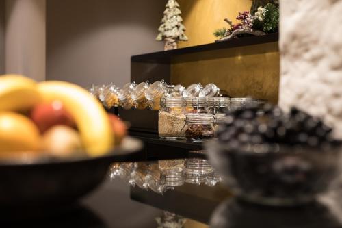 a table topped with glasses of food and fruit at Alpenhotel Tirolerhof in Fulpmes