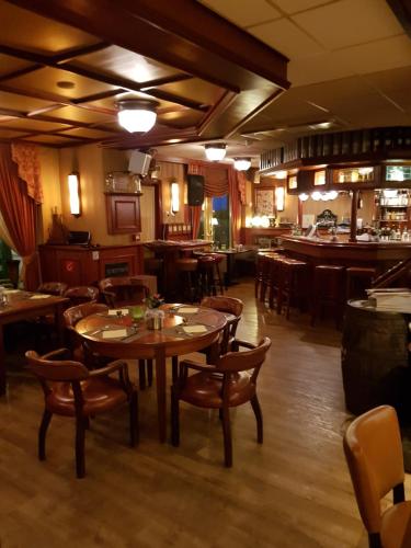 Hotel Zee en Duin في كاتفايك: مطعم مع طاولات وكراسي خشبية وبار