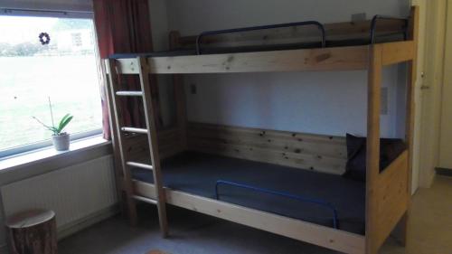 a bunk bed in a room with a window at Djurs-BnB - Rimsøhuset in Rimsø