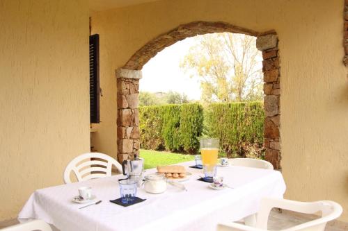 a table with a white table cloth and an archway at Villette Oasi in San Teodoro