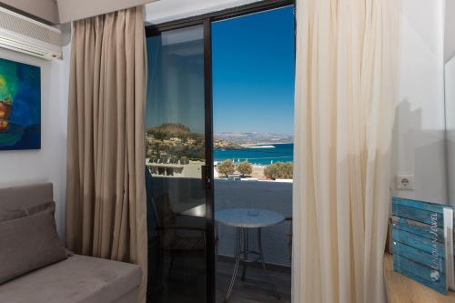 a room with a couch and a view of the ocean at Lindian Jewel Hotel and Villas in Líndos
