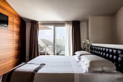 una camera con un grande letto e un balcone di Nun Assisi Relais & Spa Museum ad Assisi