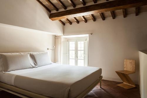a white bed in a room with a window at Nun Assisi Relais & Spa Museum in Assisi