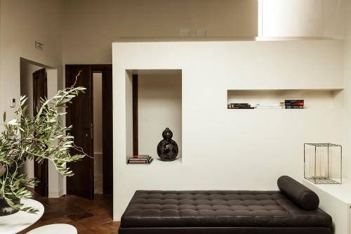 a living room with a black leather couch in a room at Nun Assisi Relais & Spa Museum in Assisi