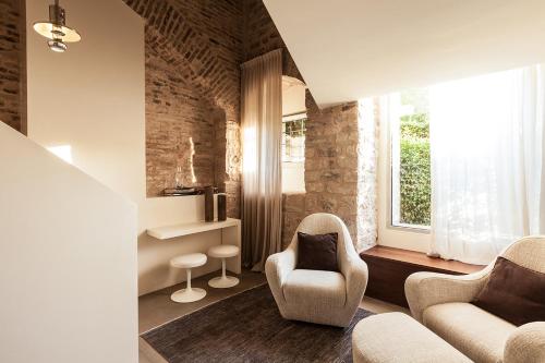 a living room with two chairs and a window at Nun Assisi Relais & Spa Museum in Assisi