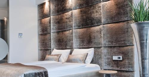 a bedroom with two beds in front of a wall at G Design Hotel in Ljubljana
