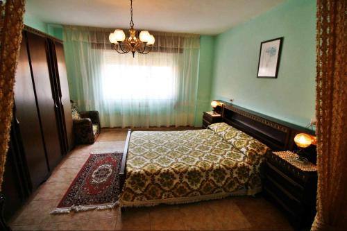 um quarto com uma cama, uma janela e um lustre em Casa Playa de Esteiro em Esteiro-Muros