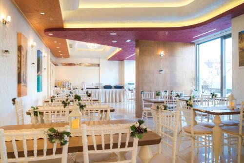 a restaurant with tables and chairs with flowers on them at Hotel Kadmo by Aycon in Budva