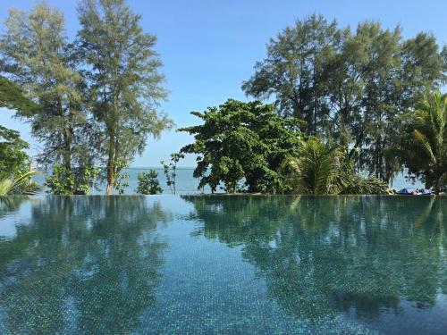 a pool of water with trees in the background at By The Sea Suite,Batu Ferringhi in Batu Ferringhi